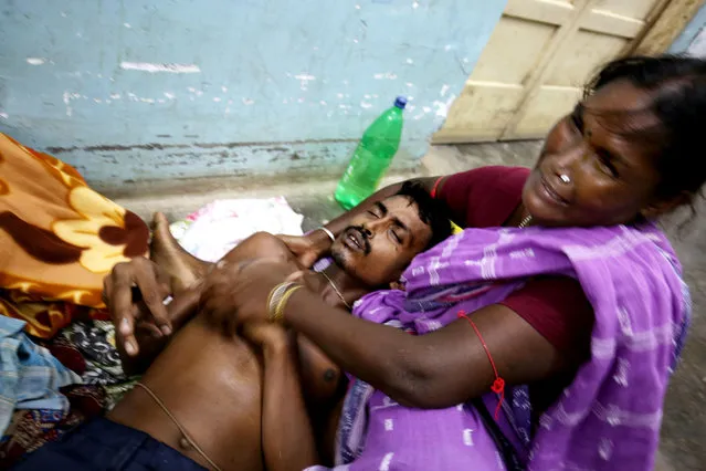 Sandha Mal (R) tries to help her son Lalu Mal who reacts with stomach pain at a hospital in Tamluk, some 115 km west  of Calcutta, India, 28 September 2015 after the victim drank poisonous liquor. At least 12 people have died and some 50 were admitted to hospitals after consuming illegal alcohol in eastern India, police said. Villagers in West Bengal state's Midnapore district fell ill after drinking the alcohol on the weekend. (Photo by Piyal Adhikary/EPA)