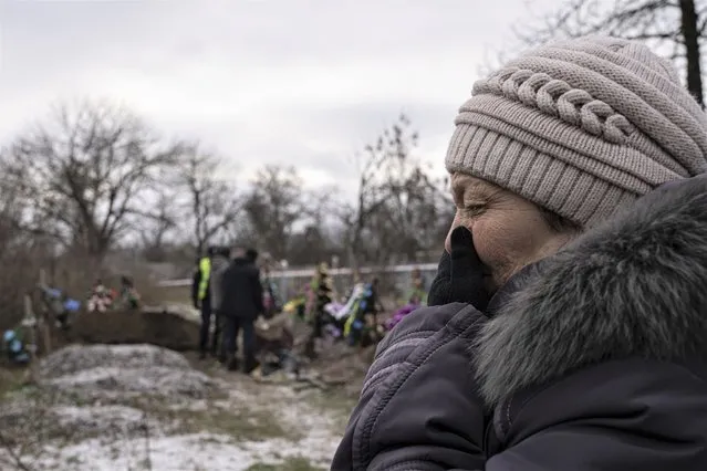 Tamila Pyhyda cries during the exhumation of her husband Serhii Pyhyda who was killed by Russian forces in the recently retaken town of Vysokopillya, Ukraine, Monday, December 5, 2022. (Photo by Evgeniy Maloletka/AP Photo)