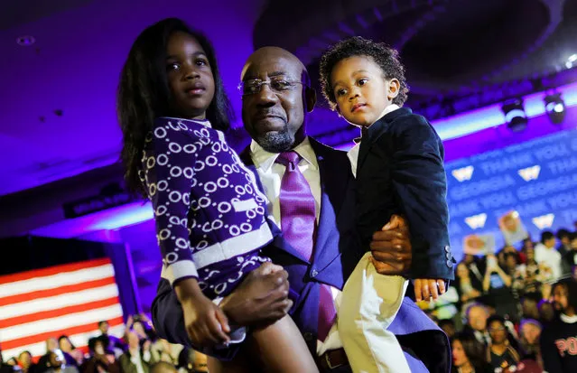 U.S. Senator Raphael Warnock (D-GA) holds his daughter Chloe and his son Caleb in his arms during an election night party after a projected win in the U.S. midterm runoff election between Warnock and his Republican challenger Herschel Walker in Atlanta, Georgia, U.S., December 6, 2022. (Photo by Carlos Barria/Reuters)
