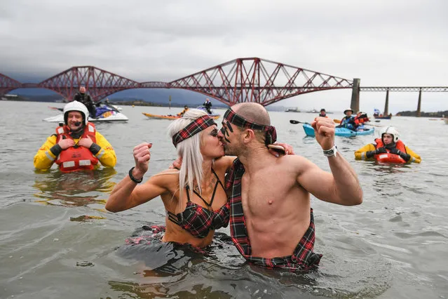 Members of the public wearing fancy dress react to the water as they join around 1100 New Year swimmers, many in costume, in front of the Forth Rail Bridge during the annual Loony Dook Swim in the River Forth on January 1, 2018 in South Queensferry, Scotland. Tens of thousands of people gathered last night in Edinburgh and other events across Scotland to see in the New Year at Hogmanay celebrations. (Photo by Jeff J. Mitchell/Getty Images)