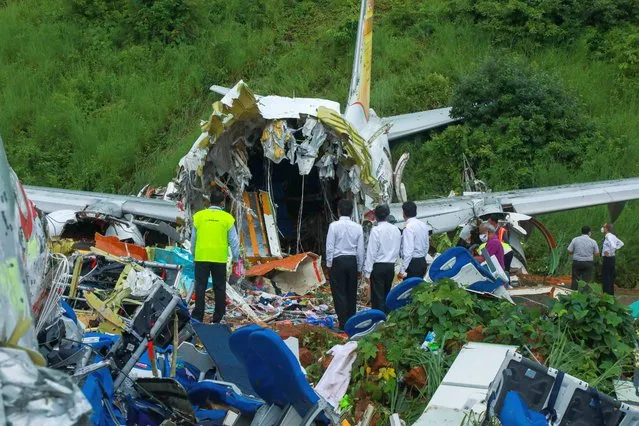 Officials inspect the wreckage of an Air India Express jet at Calicut International Airport in Karipur, Kerala, on August 8, 2020. Fierce rain and winds lashed a passenger jet carrying 190 people from Dubai that crash landed and tore in two at an airport in southern India killing at least 18 people and injuring scores more, officials said. (Photo by Arunchandra Bose/AFP Photo)