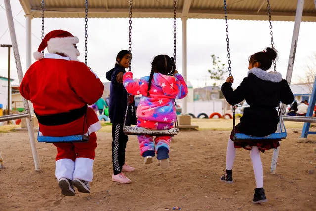 A man dressed as Santa Claus, along with other volunteers participates in a Christmas celebration for migrant children, who, along with their parents are in a shelter, while they wait to apply for asylum in the U.S., after the Supreme Court said Title 42 should stand as is for now, in Ciudad Juarez, Mexico December 25, 2022. (Photo by Jose Luis Gonzalez/Reuters)
