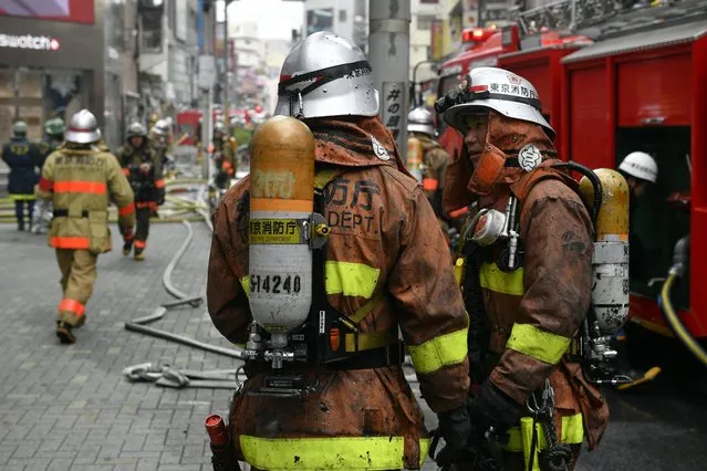 Firefighters are covered with soot as they operate on the site where a fire broke out in a building at Shibuya Center-gai Shopping Street in Tokyo, Japan, 31 December 2017. According to latest media reports, one man has been rescued but other people are feared to have been trapped. Shibuya is known for being a young people fashion center and a large countdown event is scheduled on New Year's Eve. (Photo by Franck Robichon/EPA/EFE)