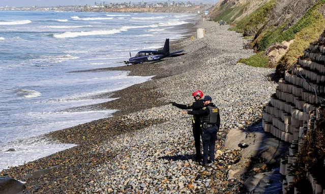 Officials investigate a small plane crash along the shoreline at South Carlsbad State Beach on Thursday, January 19, 2023, in Carlsbad, Calif. The small airplane made a safe emergency landing on a state beach on the San Diego County coast Thursday morning. Authorities say there were three people aboard the plan and no injuries were reported. (Photo by Eduardo Contreras/The San Diego Union-Tribune via AP Photo)