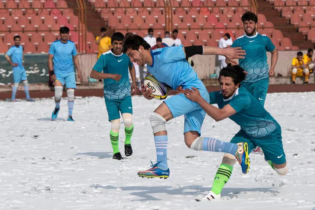 Players from Habibia High School and Ariana (in blue) compete in the Winter Rugby tournament after snowfall at Ghazi Stadium in Kabul on January 30, 2023. The Rugby Federation of Kabul with support from the National Olympic Committee, launched a one-day winter rugby tournament with participation from six teams from the four zones of Kabul. (Photo by Wakil Kohsar/AFP Photo)