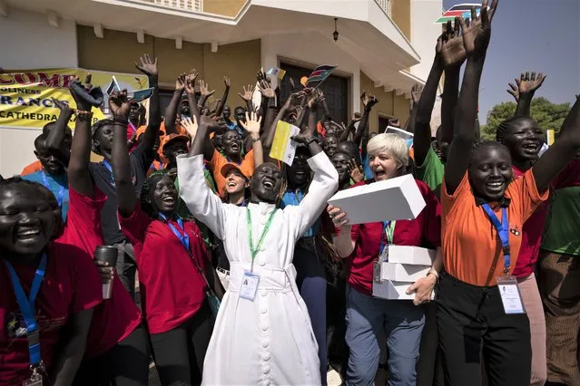 A group of the Catholic faithful from the town of Rumbek, who had walked for more than a week to reach the capital, including Sister Orla Treacy from Ireland, center-right, cheer after receiving gifts from Pope Francis after he addressed clergy at the St. Theresa Cathedral in Juba, South Sudan Saturday, February 4, 2023. (Photo by Ben Curtis/AP Photo)