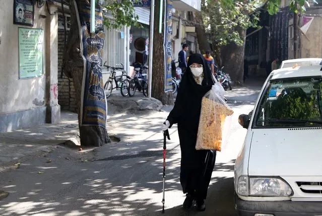 A woman wears a medical mask as a precaution against the novel coronavirus (COVID-19) pandemic as people in slums of Tehran continue to live fighting against the poverty and coronavirus in southeastern Ni'Matabad village of Tehran, Iran on October 15, 2020. People struggle to live without electricity, water and natural gas in slums and makeshift buildings, and also try to protect themselves against the coronavirus. (Photo by Fatemeh Bahrami/Anadolu Agency via Getty Images)