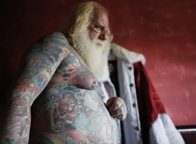 Vitor Martins displays one of his Christmas tattoos inside his house, before a performance with children in Sao Caetano do Sul's town square, near Sao Paulo, December 7, 2014. (Photo by Nacho Doce/Reuters)