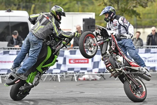 Stunt drivers show their skills at the international motorcycle exhibition in Cologne, Germany, Friday, October 7, 2016. Until Sunday the motorcycle and scooter industry shows the latest bikes from classic scramblers to the fastest racing bikes at the INTERMOT 2016 in Cologne. (Photo by Martin Meissner/AP Photo)
