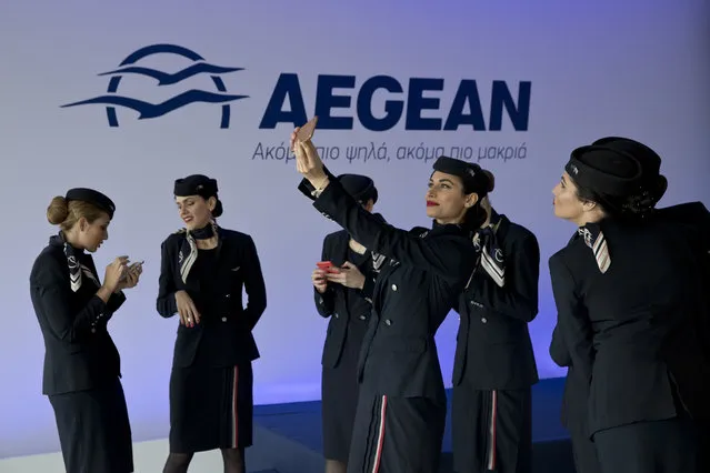 Aegean airlines air hostesses take selfies after a news conference in Athens, Wednesday, March 28, 2018. In a deal worth up to $5 billion, Greek airline Aegean says it will buy 30 new Airbus aircraft, with the option of an additional 12, to upgrade its fleet as the country expects to break tourism records. The signing of the final purchase agreement is expected in June. (Photo by Petros Giannakouris/AP Photo)