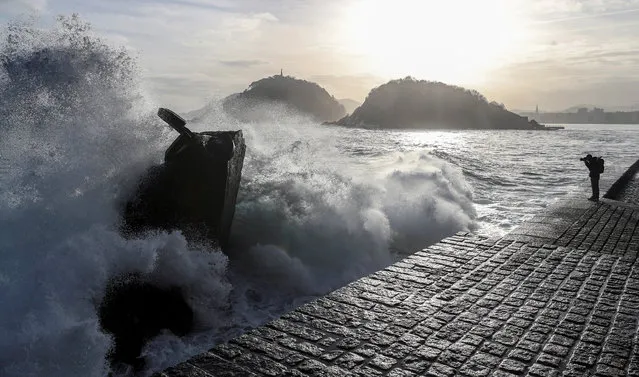 A man takes photos of huge waves breaking against Spanish artist Eduardo Chillida's sculpture “The Comb of the Wind” in San Sebastian, the Basque Country, northern Spain, 05 April 2018. (Photo by Javier Etxezarreta/EPA/EFE)