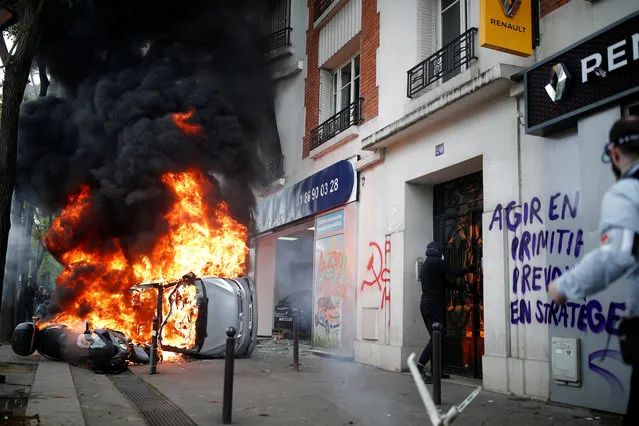 A car burns outside a Renault automobile garage during clashes during the May Day labour union march in Paris on May 1, 2018. (Photo by Christian Hartmann/Reuters)