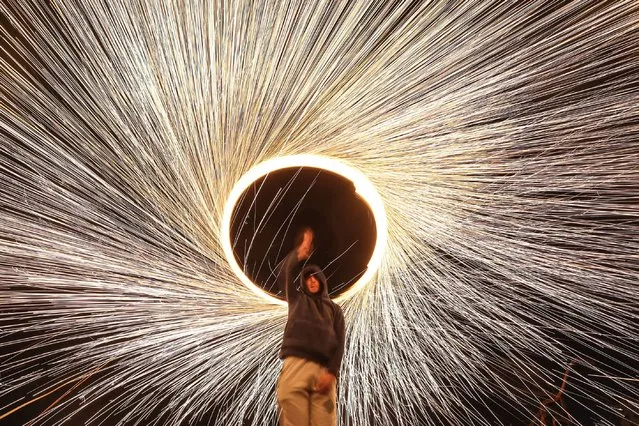 Palestinians perform to amuse people with a wire which ignites sparks during the Islamic holy fasting month of Ramadan, on April 03, 2023 in Gaza City, Gaza. (Photo by Mustafa Hassona/Anadolu Agency via Getty Images)