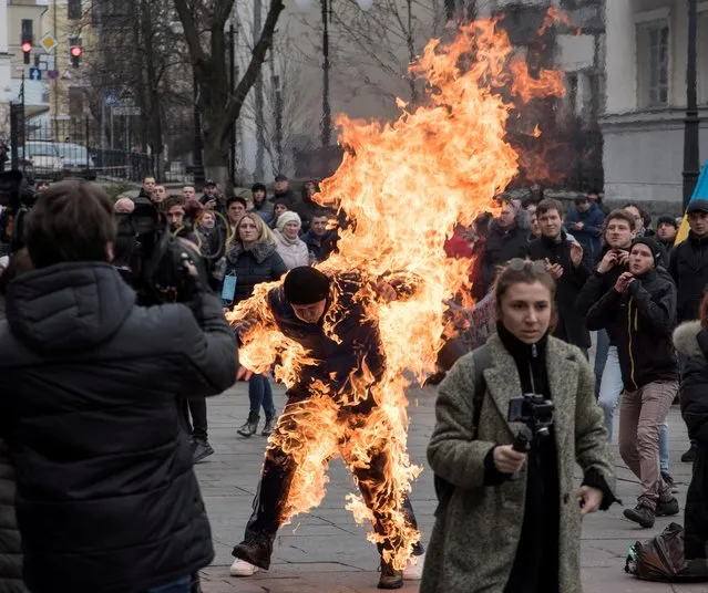 A man sets himself on fire during protest rallies in front of the presidential office in Kiev, Ukraine on February 26, 2020. The man, who called himself Oleksandr Burlakov, said subsequently that his motive was to draw the attention of the authorities to his plight, related to the ownership of the land parcel. (Photo by Ihor Behus/Reuters)