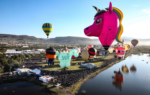 This view shows giant hot air balloons of various shapes being lifted to begin flights from the Metropolitan Park over the city of Leon during the 2025 International Balloon Festival (FIG) in the state of Leon, Mexico on November 14, 2025. (Photo by Mario Armas/AFP Photo)