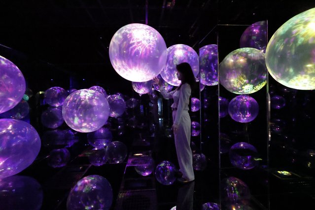 A staff member interacts with artwork during a preview of the new museum “teamLab Biovortex Kyoto” in Kyoto, western Japan, 24 September 2025. Art collective teamLab will open to the public its new permanent art museum, teamLab Biovortex Kyoto, on 07 October 2025. The facility will be teamLab's largest museum in Japan, featuring more than 50 artworks. (Photo by Franck Robichon/EPA)