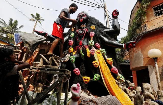 An artist puts artificial hair on an idol of the Hindu goddess Kali inside a workshop ahead of the Kali Puja festival in Kolkata, India October 24, 2016. (Photo by Rupak De Chowdhuri/Reuters)