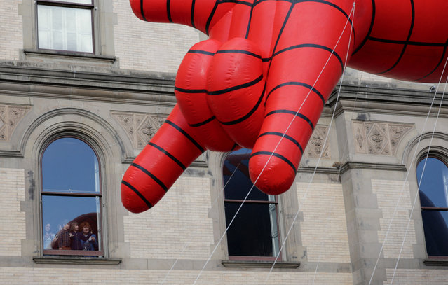 Children watch from a window as the Spider-Man balloon goes past during the Macy's Thanksgiving Day Parade 2025, in New York City, U.S., November 27, 2025. (Photo by Jeenah Moon/Reuters)
