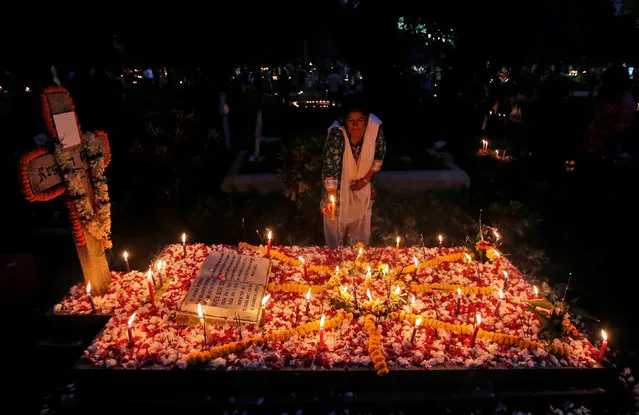 A woman lights a candle on the grave of her relative before praying at a cemetery during the observance of All Souls Day in Kolkata, India November 2, 2016. (Photo by Rupak De Chowdhuri/Reuters)