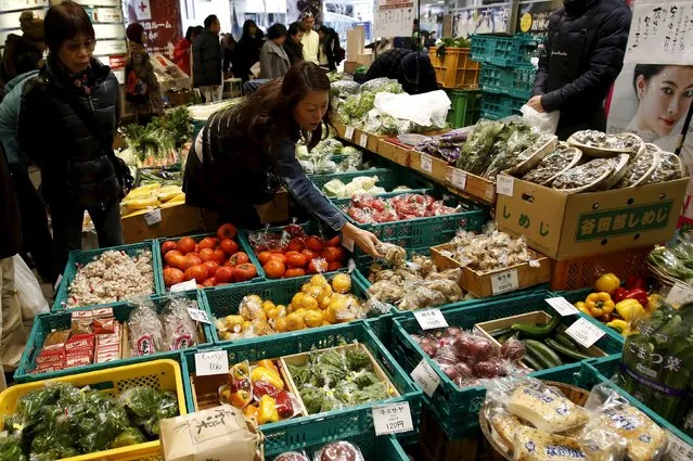 A shopper looks at packs of vegetables at a market at a shopping district in Tokyo, Japan, December 6, 2015. (Photo by Yuya Shino/Reuters)