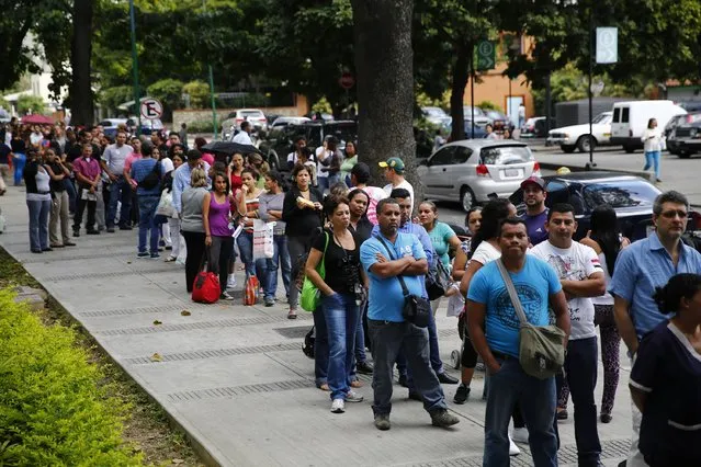 People line up outside a pharmacy to buy baby diapers in Caracas January 19, 2015. (Photo by Jorge Silva/Reuters)