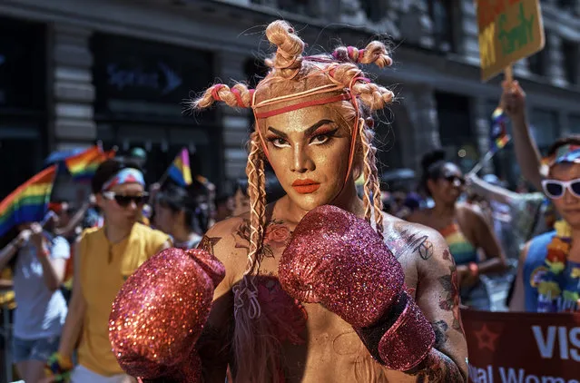 A reveler pauses for a picture during the New York City Pride Parade, Sunday, June 24, 2018. (Photo by Andres Kudacki/AP Photo)
