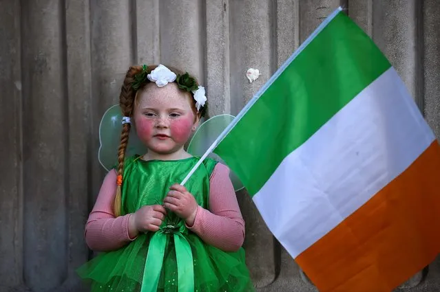 Willow O'Brien, 5, holds an Irish flag as she poses for pictures, amid the outbreak of the coronavirus disease (COVID-19), on Saint Patrick's Day in Dublin, Ireland, March 17, 2021. (Photo by Clodagh Kilcoyne/Reuters)