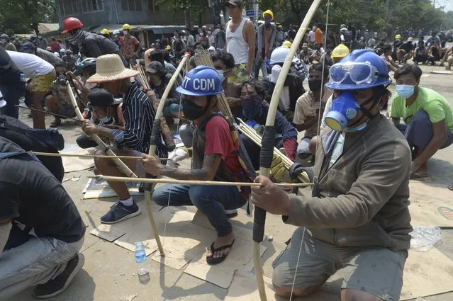 Anti-coup protesters prepare makeshift bow and arrows to confront police in Thaketa township Yangon, Myanmar, Saturday, March 27, 2021. (Photo by AP Photo/Stringer)