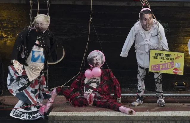 Joe Corre, the son of Vivienne Westwood and s*x Pistols creator Malcolm McLaren (not in picture) prepares to burn his entire £5 million punk collection on models featuring face masks of Boris Johnson, British Prime Miinister Theresa May and Jeremy Hunt on November 26, 2016 in London, England. Joe Corre burnt the rare punk memorabilia in protest saying punk has no solutions for today's youth and is “conning the young”. (Photo by John Phillips/Getty Images)