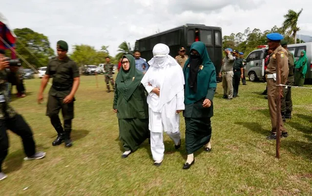 An Acehnese woman escorted by the sharia police officers as she faces a public caning punishment for having a sexual relationship without being married, in Jantho, Aceh, Indonesia, 20 July 2018. Aceh is the only province in Indonesia that has implemented the Sharia as a law and considers lesbian, gay or bisexual relationships as well as s*x outside of marriage as violations to Sharia law. (Photo by Hotli Simanjuntak/EPA/EFE)