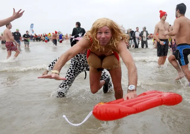 A participant jumps in the waters of the North Sea during the annual New Year's plunge event in Ostend, Belgium, January 2, 2016. (Photo by Francois Lenoir/Reuters)