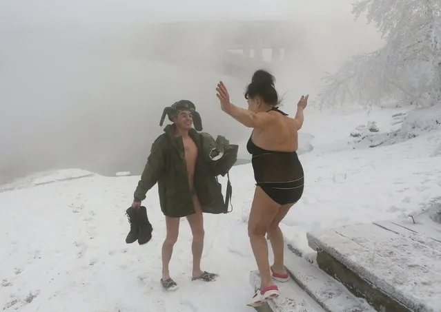 Mikhail Shakov (L), 23, who recently left the army and is a member of the Cryophile winter swimmers club, greets another member on the banks of the Yenisei River in the Siberian city of Krasnoyarsk, Russia, November 21, 2015. The air temperature was some minus 27 degrees Celsius. For Shakov, swimming is a way of disconnecting from daily life and setting his troubles to one side. "All problems leave me," he says. "The world around me seems beautiful". (Photo by Ilya Naymushin/Reuters)