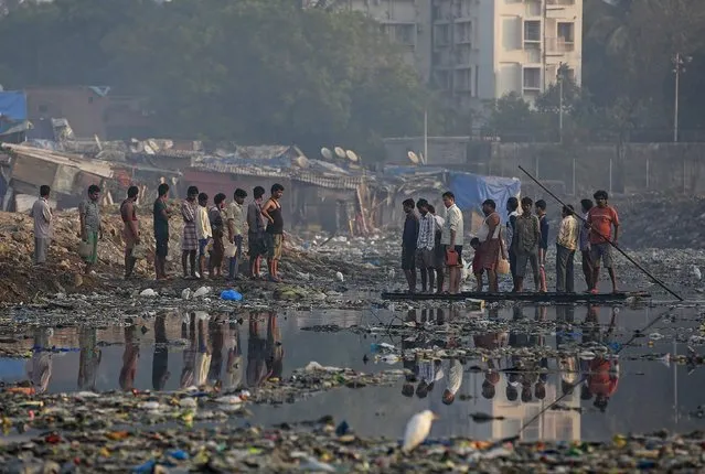 Residents use an improvised raft to cross a sewage canal at a slum in Mumbai February 11, 2015. Residents pay 2 Indian rupees ($0.03) for a single trip. (Photo by Danish Siddiqui/Reuters)