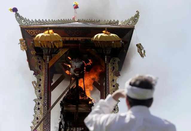 A Balinese man watches the cremation of Ida Anak Agung Ayu Oka Pemecutan, a member of the Denpasar royal family, during a Hindu Ngaben, or cremation ceremony,  in Denpasar, Bali, November 14, 2018. (Photo by Johannes P. Christo/Reuters)