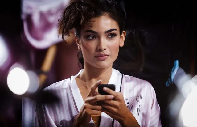 Kelly Gale uses her phone backstage before the taping of the 2013 Victoria's Secret Fashion Show. (Photo by Carlo Allegri/Reuters)
