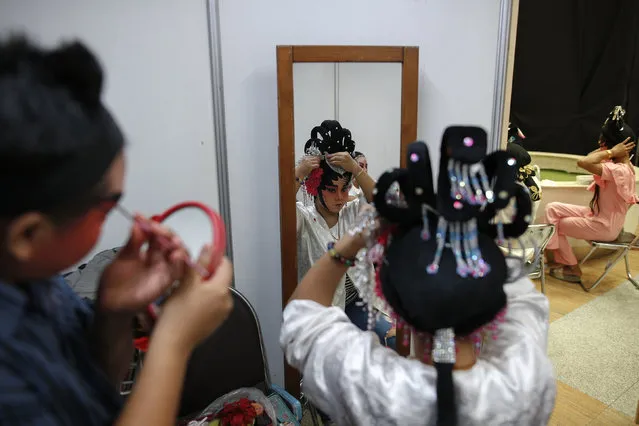 Members of a Chinese opera troupe apply make-up before a performance at a shopping mall ahead of the Chinese Lunar New Year celebrations in Bangkok, Thailand, February 4, 2016. (Photo by Athit Perawongmetha/Reuters)