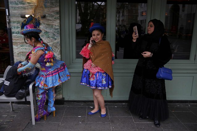 A woman photographs Bolivian performers before the New Year's day parade in London, Britain January 1, 2017. (Photo by Neil Hall/Reuters)