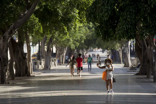 People walk through Paseo del Prado in Havana, Cuba, Monday, July 12, 2021, the day after protests against food shortages and high prices amid the coronavirus crisis. (Photo by Ismael Francisco/AP Photo)