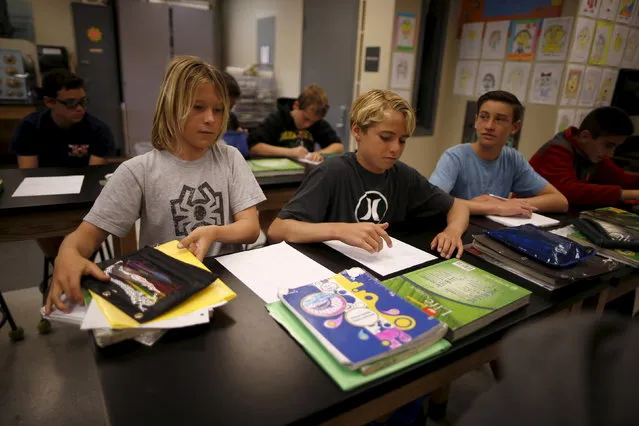 (L-R) Shane Moseley, 13, Kieran Walls, 13, and Luke Personius, 12, sit in class at Hermosa Valley School after surfing at sunrise in Hermosa Beach, California, April 2, 2015. (Photo by Lucy Nicholson/Reuters)