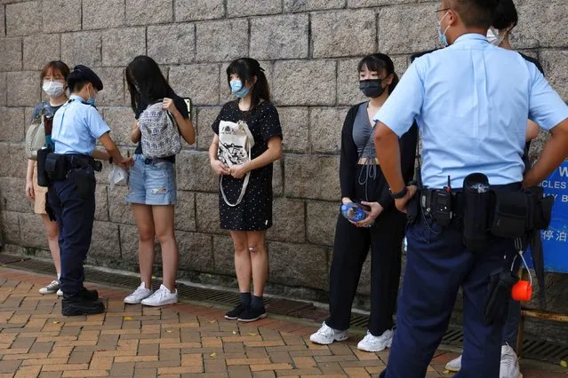 Police stop and search supporters of Tong Ying-kit, the first person charged under a new national security law, during court hearing outside the High Court, in Hong Kong, China. on July 30, 2021. (Photo by Tyrone Siu/Reuters)