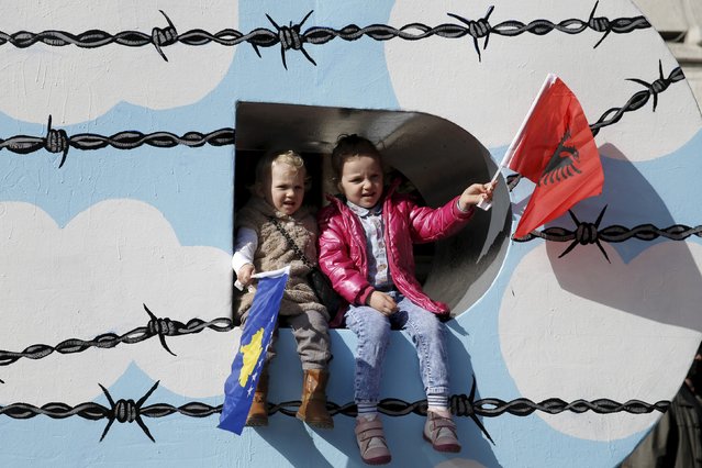 Children wave Albanian (R) and Kosovar flags on the “Newborn” monument during a celebration marking the eighth anniversary of Kosovo's declaration of independence from Serbia, in Pristina February 17, 2016. (Photo by Marko Djurica/Reuters)