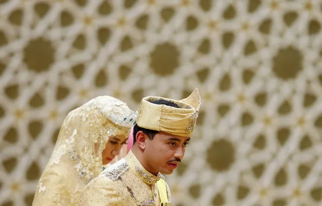 Brunei's newly wed royal couple, Prince Abdul Malik and Dayangku Raabi'atul 'Adawiyyah Pengiran Haji Bolkiah, leave the “bersanding” or enthronement ceremony at their wedding in the Nurul Iman Palace in Bandar Seri Begawan April 12, 2015. (Photo by Olivia Harris/Reuters)