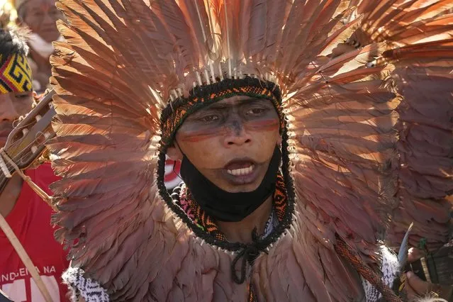An Indigenous man takes part in a ritual during the “Luta pela Vida”, or Struggle for Life mobilization, a protest to pressure Supreme Court justices who are expected to issue a ruling that will have far-reaching implications for tribal land rights, outside the Supreme Court in Brasilia, Brazil, Wednesday, August 25, 2021. (Photo by Eraldo Peres/AP Photo)
