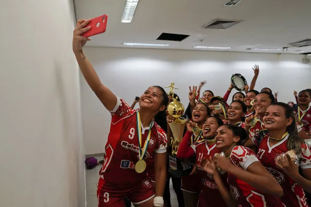 Salcomp soccer players take a selfie in the dressing room after winning the Peladao amateur soccer tournament at Arena da Amazonia in Manaus, Brazil, Saturday, February 16, 2019. The majority of Peladao players do not dream of turning professional, although a few have managed to do that with small clubs in Brazil's northern states. (Photo by Victor R. Caivano/AP Photo)