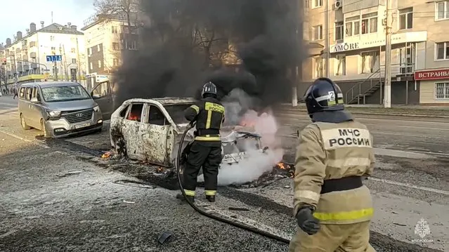 In this photo taken from video released by Russia Emergency Situations Ministry telegram channel on Saturday, December 30, 2023, Firefighters extinguish burning cars after shelling in Belgorod, Russia. Russian officials have accused Ukrainian forces of shelling the Russian border city of Belgorod. Two children were killed in Saturday's attack, regional governor Vyacheslav Gladkov said in a statement on social media. He also said that an unspecified number of people had been injured. (Photo by Russia Emergency Situations Ministry telegram channel via AP Photo)
