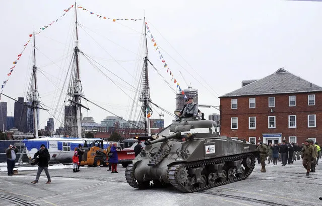World War II tank gunner Clarence Smoyer sits atop a tank as he passes the historic frigate U.S.S. Constitution at the Charlestown Naval Shipyard in Boston, Wednesday, February 20, 2019. The 95-year-old veteran was surprised with a ride through the streets of Boston in a Sherman tank, one of the tanks most widely used by the U.S. during the war. (Photo by Charles Krupa/AP Photo)
