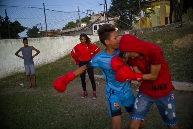 In this January 19, 2017 photo, boxer Idamerys Moreno, center back, looks at children playing around, at a sports center in Havana, Cuba. Boxing has long been an athletic engine for Cuba, which has won 72 Olympic medals in that category but women are not allowed to box. (Photo by Ramon Espinosa/AP Photo)