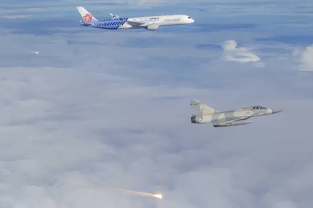 In this photo released by the Military News Agency, Mirage-2000 jet fighters of Taiwan's Air Force fire their flares as they fly alongside China Airlines flight CI-101to honor the return of Taiwan's badminton Olympians as the plane approach the Taoyuan International Airport in Taiwan on Wednesday, August 4, 2021. Taiwan's Olympic badminton team flew home cheerfully acclaimed by their fans at the airport as they bring back two gold medals and a silver medal respectively in the category of men's double and women's single. (Photo by Military News Agency via AP Photo)