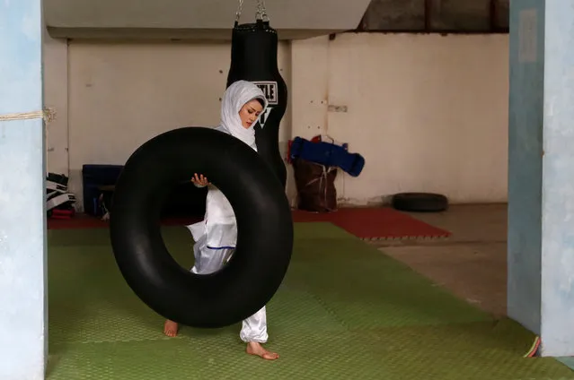 Sabera Bayanne, 20, a student at the Shaolin Wushu club, carries a tube before an exercise in Kabul, Afghanistan January 29, 2017. On a snowy mountaintop to the west of Kabul, a group of Afghan girls practise the flowing movements of Wushu, a sport developed from ancient Chinese kung fu martial arts, stretching and bending and slashing the air with bright swords. In a country where women's sport is severely restricted, the Shaolin Wushu club in a part of Kabul that is home to the capital's Hazara ethnic community, is a rare exception. Sima Azimi, the 20-year-old leading the practice session, says Wushu teaches self-defence, but just as important, “it's really effective for body and soul”. Martial arts of all kinds are popular in Afghanistan, but it is a notoriously hard country for women, and the girls of the Shaolin Wushu club face regular harassment and abuse in addition to the normal dangers of life in Kabul. When possible, training goes on in a gym dominated by a poster of Hussain Sadiqi, a Hazara martial arts champion who fled to Australia in 1999 and later worked as a film stuntman. So far, all the girls in the club are Hazara, a Persian-speaking, mainly Shi'ite group who have faced a series of attacks claimed by Islamic State militants over the past year. (Photo by Mohammad Ismail/Reuters)