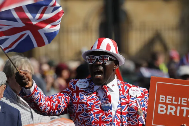 A Brexit supporter waves a Union Jack at Parliament Square in Westminster, London, Friday, March 29, 2019. Pro-Brexit demonstrators were gathering in central London on the day that Britain was originally scheduled to leave the European Union. British lawmakers will vote Friday on what Prime Minister Theresa May's government described as the “last chance to vote for Brexit”. (Photo by Frank Augstein/AP Photo)
